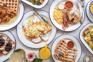 uma mesa coberta com pratos de pequeno-almoço e waffles em Lucky Central Hotel & Travel em Hanói