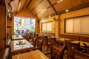 a restaurant with wooden tables and chairs and a large screen at M Square Hotel in Hyderabad