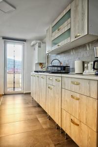una cucina con armadi in legno e una grande finestra di Marko’s apartament a Sighişoara