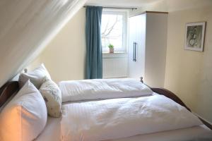 a bedroom with two beds with white sheets and a window at Ferienwohnung Hof Margarethental 