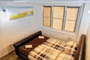 una camera da letto con un letto e due finestre di Marko’s apartament a Sighişoara