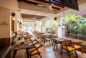 a restaurant with wooden tables and chairs and windows at M Square Hotel in Hyderabad