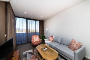 uma sala de estar com um sofá e uma mesa em Arte Apartments Braddon em Camberra