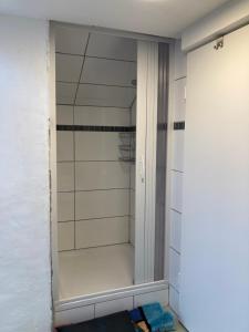 a shower with a glass door in a bathroom at Gemütlicher Schäferwagen im Grünen-Schäferwagen 44 in Frielendorf