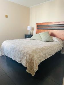 um quarto com uma cama grande e uma colcha branca em condominio Los tamarindos 4 depto 227 torre 2, oscar quiroz morgado 1889 em La Serena