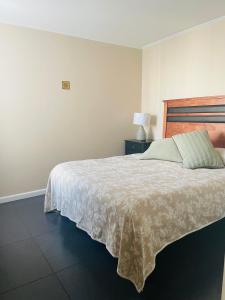 um quarto com uma cama grande e uma colcha branca em condominio Los tamarindos 4 depto 227 torre 2, oscar quiroz morgado 1889 em La Serena