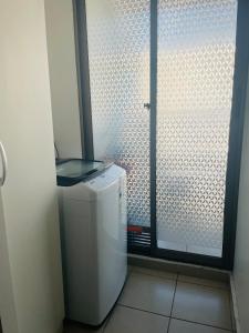 a small refrigerator in a room with a glass door at condominio Los tamarindos 4 depto 227 torre 2, oscar quiroz morgado 1889 in La Serena