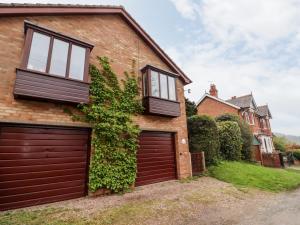 een stenen huis met een houten garagedeur bij Yew Tree Cottage in Great Malvern