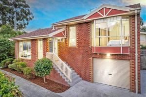 a red brick house with a garage at Charming Convenient 2BR Compact House Ringwood in Ringwood