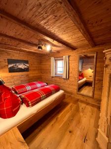 um quarto com uma cama num chalé de madeira em Auf'm Feggenlehen em Ramsau