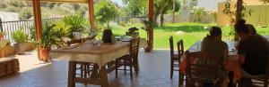 卡羅伊黎蒙涅斯的住宿－Notia Gi，一群人坐在庭院的桌子上