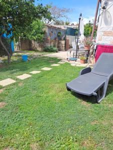 una panchina seduta sull'erba in un cortile di Appartamento con giardino a Civitavecchia