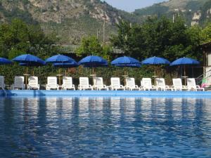 a group of chairs and umbrellas next to the water at Fiori D'Arancio in Piano di Sorrento