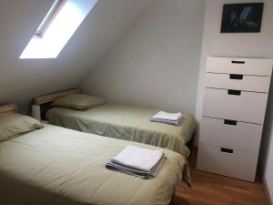 a attic bedroom with two beds with towels on them at Maison avec jardin au calme proche centre-ville in Vannes