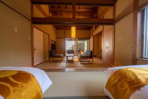a bedroom with two beds and a living room at yukairouKikuya in Izu