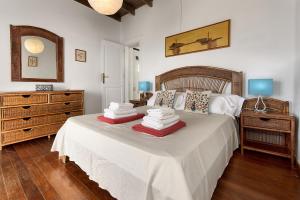 a bedroom with a bed with a dresser and a mirror at Casa La Marea in Punta Mujeres