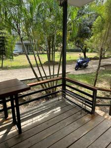 um banco com uma mesa e uma scooter num parque em Fine Times Resort em Ko Chang