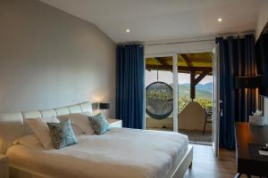 a bedroom with a bed and a sliding glass door at SWIM LODGE HOTEL Piscine privée ou Jacuzzi privé in Porto-Vecchio