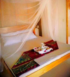 Playa Paraiso Nagtabon Beach في Bacungan: سرير بستارة بيضاء ومنشفة