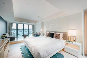 Un dormitorio con una cama grande y una ventana grande. en The Pier Hotel, en Hong Kong