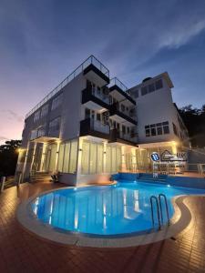 a large building with a swimming pool in front of it at 15BR SwimmingPool Villa Golf View Snooker BBQ in Bayan Lepas