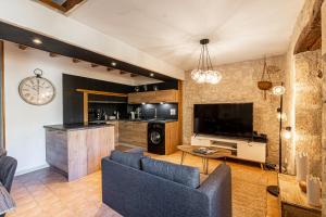 ein Wohnzimmer mit einem Sofa und einem TV in der Unterkunft Superbe appartement, situé au cœur de la ville. in Auch