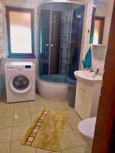 a bathroom with a washing machine and a sink at CICHY ZAKĄTEK in Borysówka