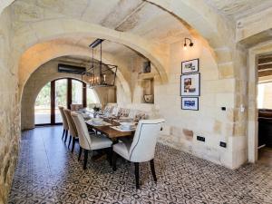 a dining room with a table and chairs at Luxury Farmhouse Villa surrounded with Nature & Farm Animals Alpacas etc in Għasri