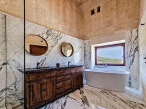 y baño con bañera, lavabo y espejo. en Luxury Farmhouse Villa surrounded with Nature & Farm Animals Alpacas etc, en Għasri