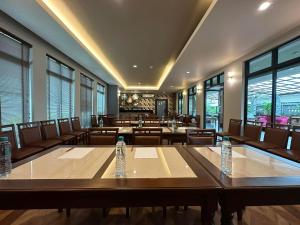 una sala de conferencias con mesas, sillas y ventanas en The Mangrove Hotel en Na Jomtien