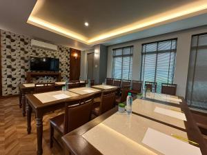 een vergaderzaal met tafels en stoelen en een televisie bij The Mangrove Hotel in Na Jomtien