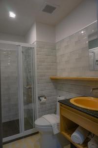 a bathroom with a shower and a toilet and a sink at Ago Hotel Chinatown in Bangkok