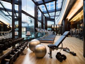 un gimnasio con una fila de cintas de correr y pesas en Bengaluru Marriott Hotel Whitefield, en Bangalore