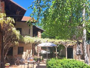 a patio with a table and an umbrella in front of a house at Cascina La Commenda in Peveragno
