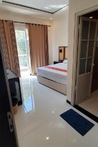 1 dormitorio con 1 cama, TV y puerta en flavianohills en Lamongan