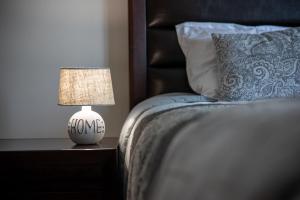 a lamp on a night stand next to a bed at Coresi rezidence & suites in Braşov