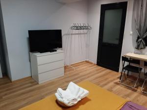 a living room with a tv and a table at ΑΝΕΤΟ ΣΤΟΥΝΤΙΟ ΣΤΗΝ ΠΥΛΑΙΑ ΜΕ ΕΥΚΟΛΟ ΠΑΡΚΙΓΚ in Thessaloniki