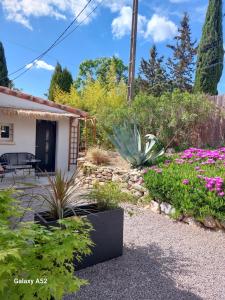 a garden in front of a house with flowers at La Micocoule in La Barben