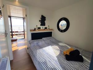 1 dormitorio con 1 cama y reloj en la pared en Hausboot Hilja - neuer Ankerplatz!, en Schleswig