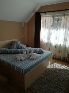 a bedroom with a bed with towels on it at Casa Bran in Buşteni