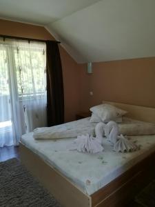 um quarto com uma cama com lençóis brancos e almofadas em Casa Bran em Buşteni