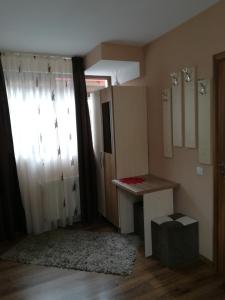 um quarto com um lavatório, uma janela e uma mesa em Casa Bran em Buşteni