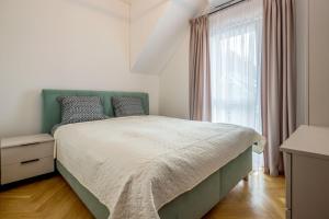 a bedroom with a green bed and a window at Vytauto 226 in Palanga