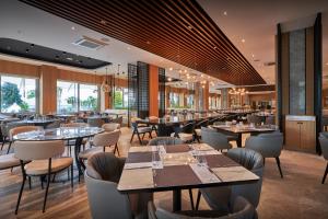 un ristorante con tavoli, sedie e finestre di Richmond Ephesus Resort - All Inclusive a Kusadası