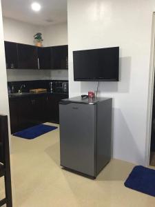 a kitchen with a tv on top of a refrigerator at Donadel Hometel in Iloilo City