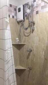 a shower with a shower head in a bathroom at Donadel Hometel in Iloilo City