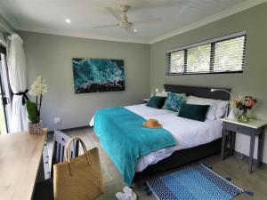 um quarto com uma cama com um cobertor azul em The Bird Hide Luxury Self catering em White River