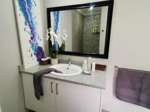 a bathroom with a sink and a mirror at The Bird Hide Luxury Self catering in White River