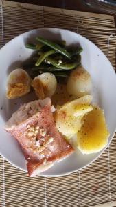 un plato de comida con carne y verduras en una mesa en Ruis Place en Vila Praia Do Bilene