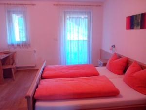 a living room with red pillows on a bed at Prestihof in San Vigilio Di Marebbe